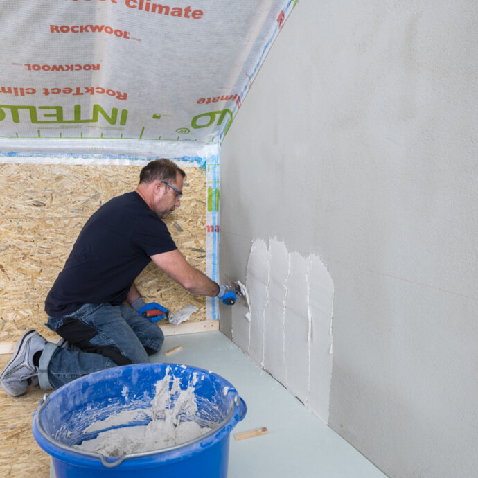 Kleber für den Klimaboard Trockenputz mit Zahnkelle auf die Wand auftragen