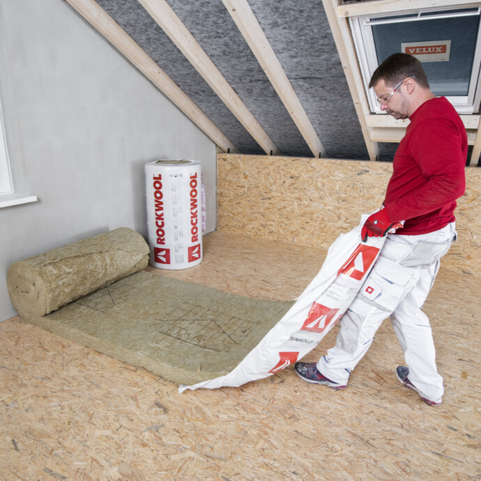 Die Rolle Klemmfilz Dachdämmung beim Öffnen der Verpackungsfolie gegen eine Wand abrollen lassen.