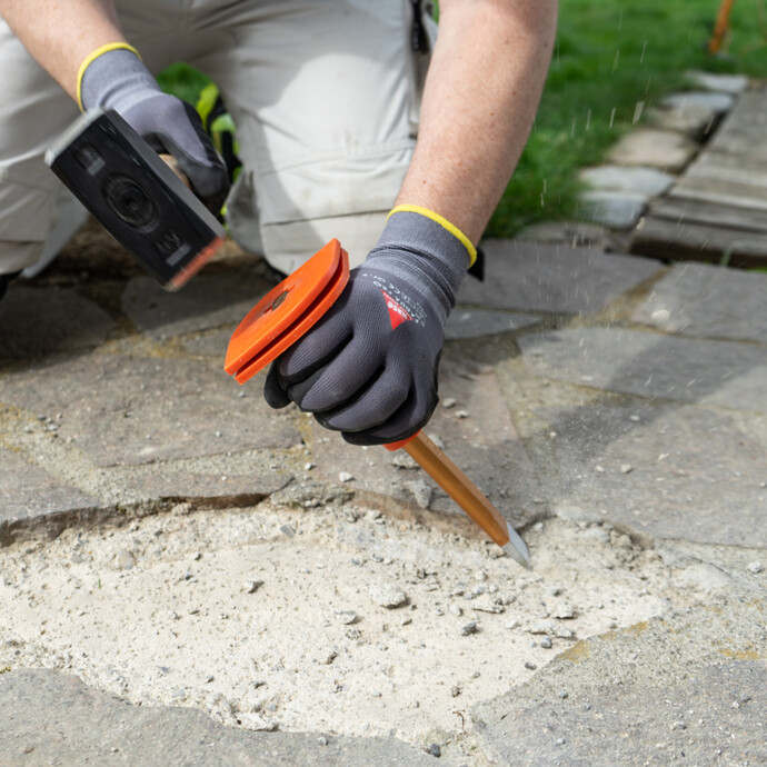 Alten Kleber der Natursteinplatten mit Hammer und Meisel entfernen.